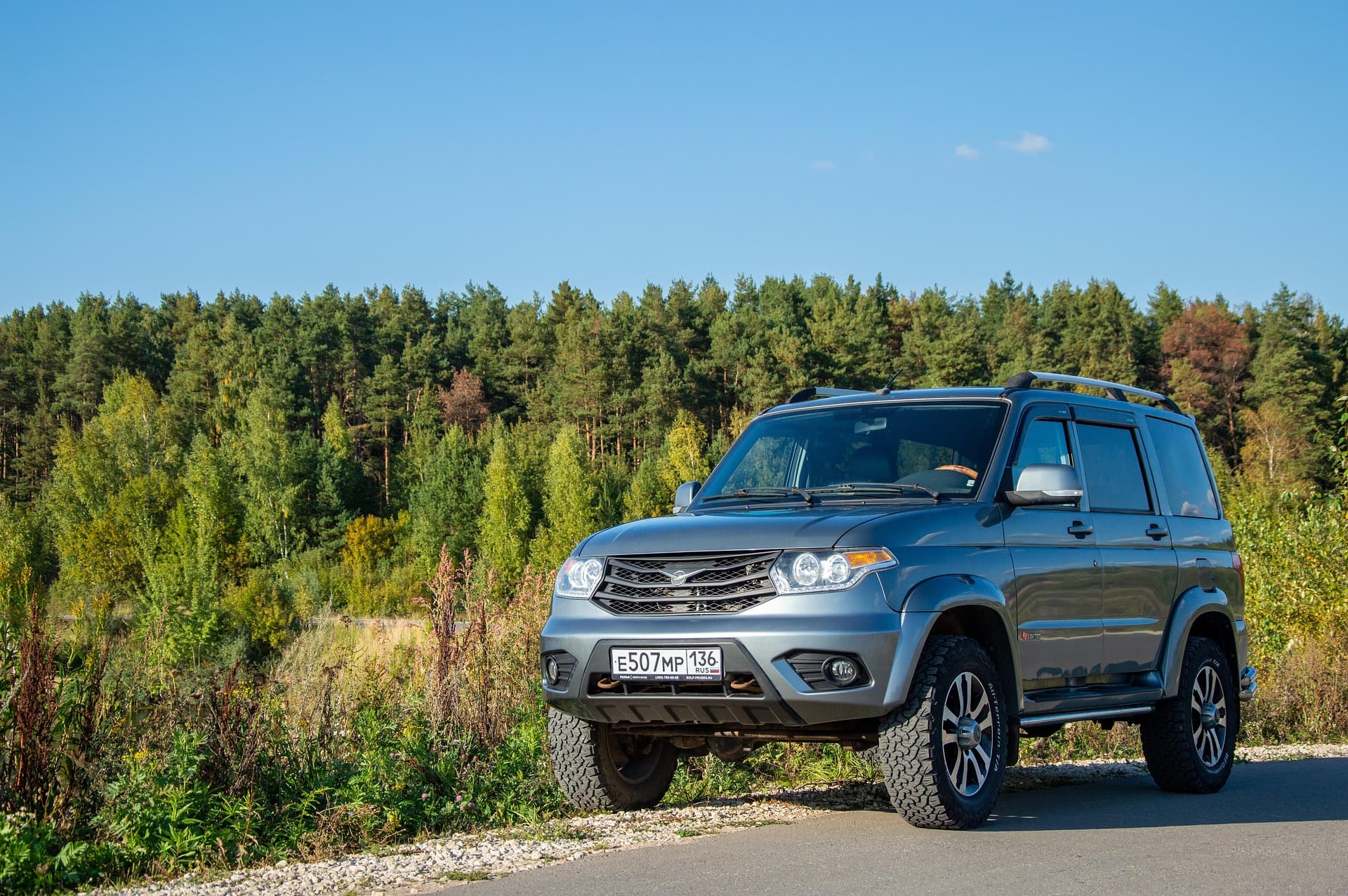 Silver SUV parked on a roadside near a forest, highlighting vehicle protection and reliability